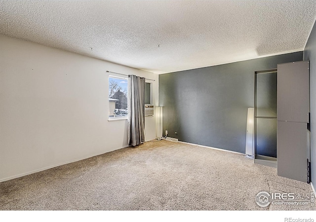 carpeted empty room with a textured ceiling