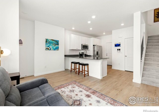 living room with sink and light hardwood / wood-style floors