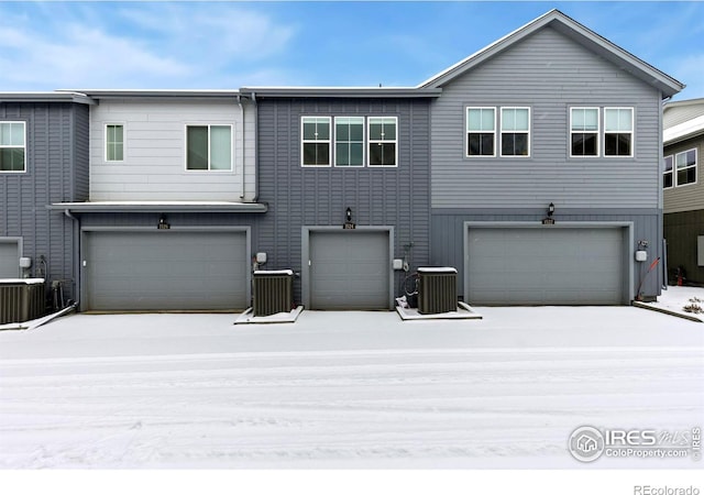 view of front of home with central AC unit and a garage