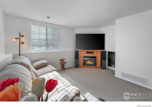 living room with light carpet and a textured ceiling