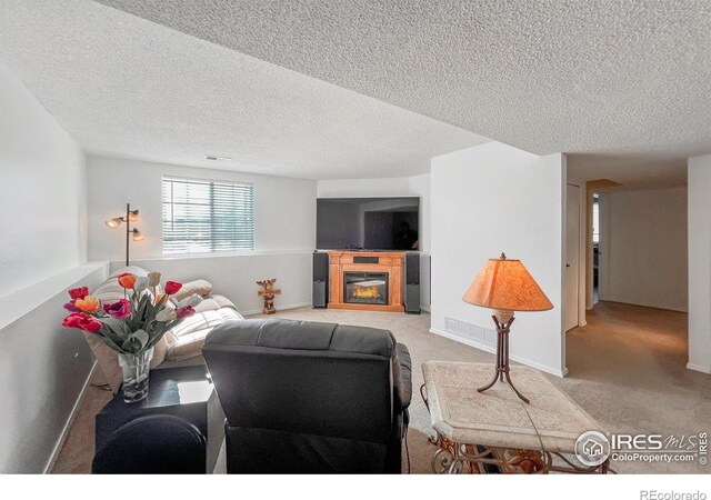 carpeted living room featuring a textured ceiling