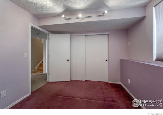 unfurnished bedroom featuring carpet flooring, a textured ceiling, and a closet