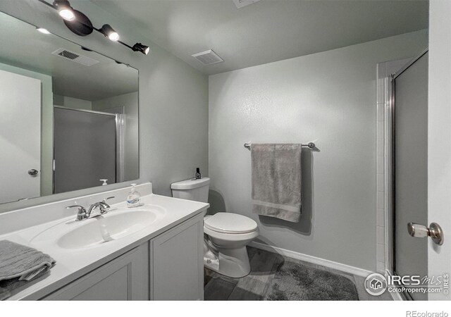 bathroom with vanity, toilet, and a shower with shower door