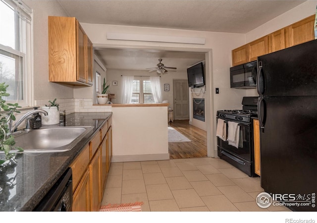 kitchen with kitchen peninsula, sink, ceiling fan, and black appliances