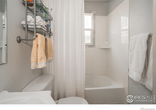 bathroom featuring shower / bath combination with curtain and toilet