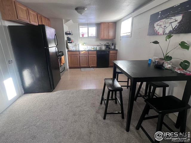 kitchen with black appliances, light tile patterned floors, and a textured ceiling