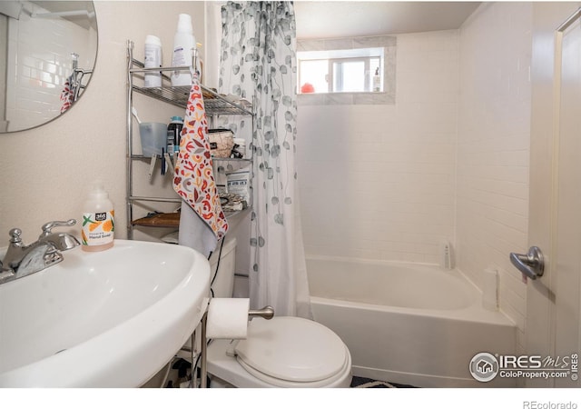 full bathroom with sink, shower / bathtub combination with curtain, and toilet