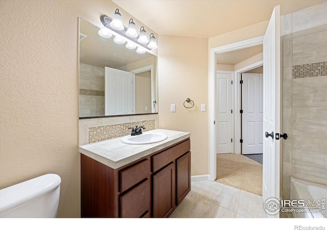 bathroom with toilet, tile patterned flooring, decorative backsplash, and vanity