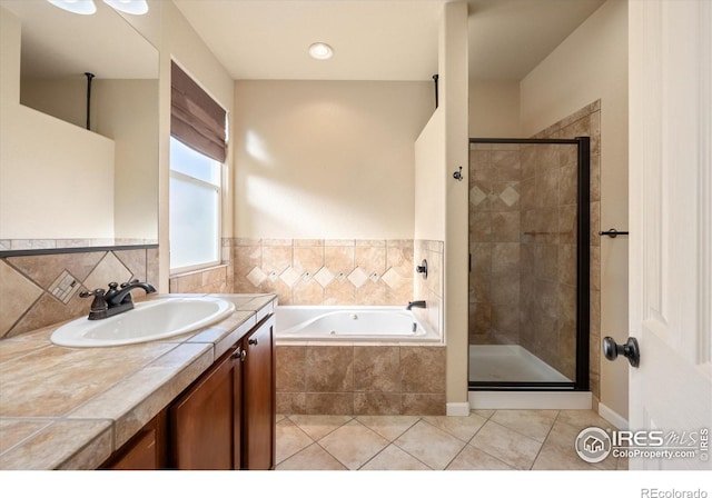 bathroom featuring tile patterned flooring, shower with separate bathtub, and vanity