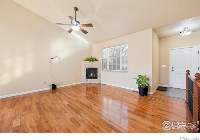 unfurnished living room with lofted ceiling, a fireplace, ceiling fan, and hardwood / wood-style flooring