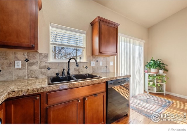 kitchen featuring sink, light wood-type flooring, dishwasher, and a wealth of natural light