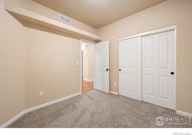 unfurnished bedroom with a closet and carpet flooring