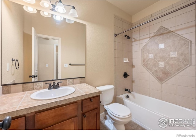 full bathroom featuring toilet, vanity, and tiled shower / bath