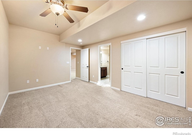 unfurnished bedroom with ceiling fan, light colored carpet, connected bathroom, and a closet