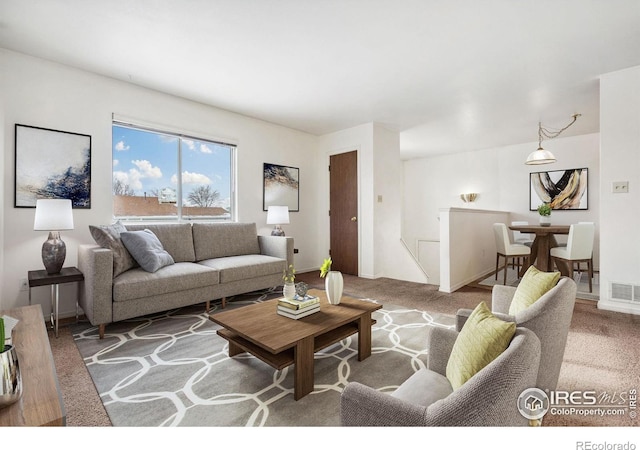 carpeted living room featuring visible vents and baseboards