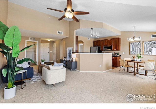 carpeted living room with vaulted ceiling and ceiling fan with notable chandelier