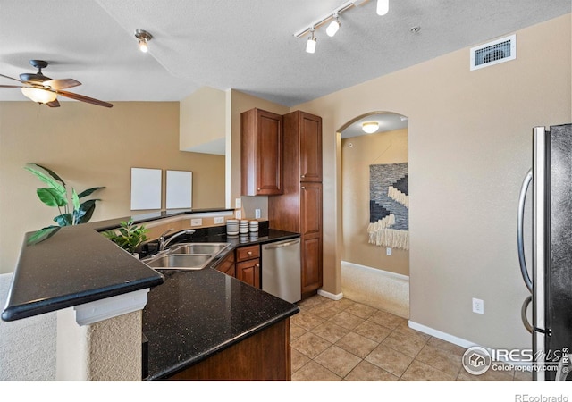 kitchen with kitchen peninsula, appliances with stainless steel finishes, a textured ceiling, ceiling fan, and sink