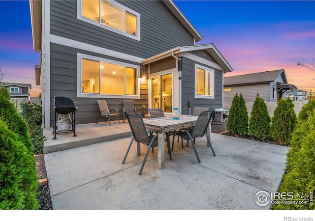 patio terrace at dusk featuring grilling area