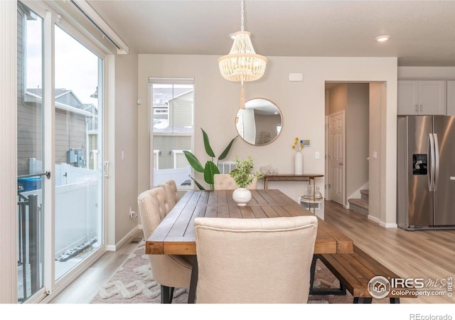 dining space with a chandelier and light hardwood / wood-style floors