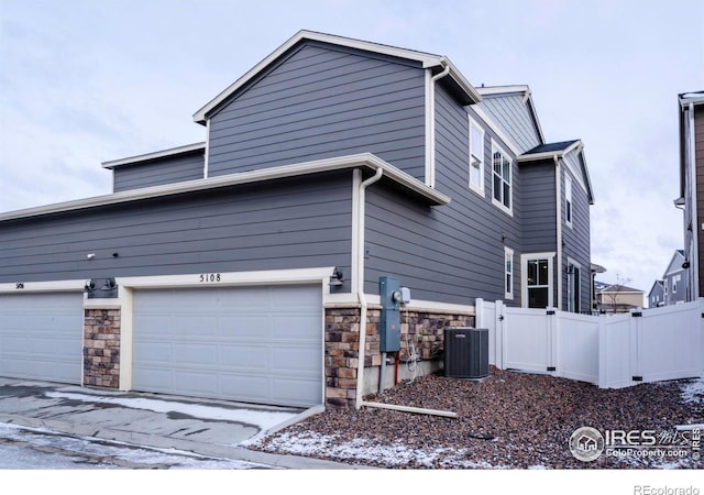 view of home's exterior with central AC and a garage