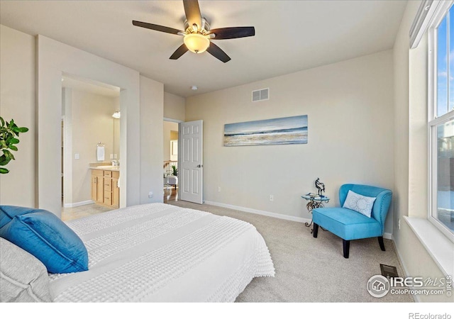 carpeted bedroom with ensuite bathroom and ceiling fan