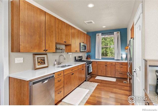 kitchen with sink, light hardwood / wood-style floors, and appliances with stainless steel finishes