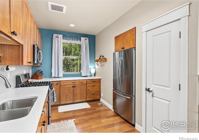 kitchen featuring sink, stainless steel appliances, and light hardwood / wood-style floors