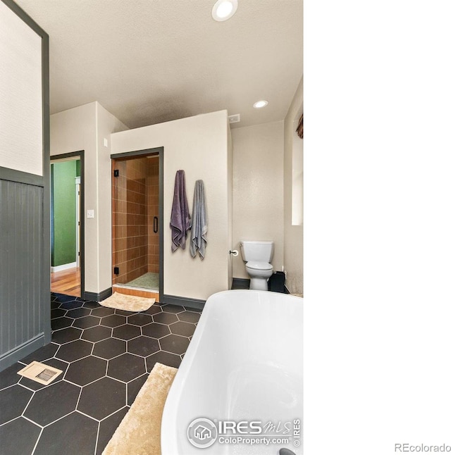 bathroom featuring toilet and shower with separate bathtub