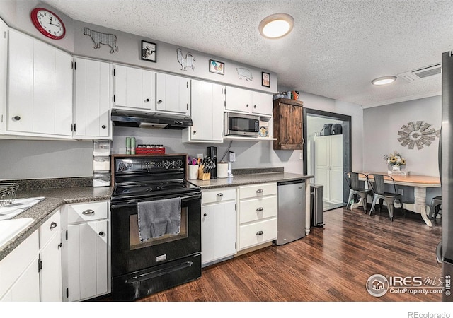 kitchen with refrigerator, a textured ceiling, dark wood-type flooring, white cabinets, and black electric range oven