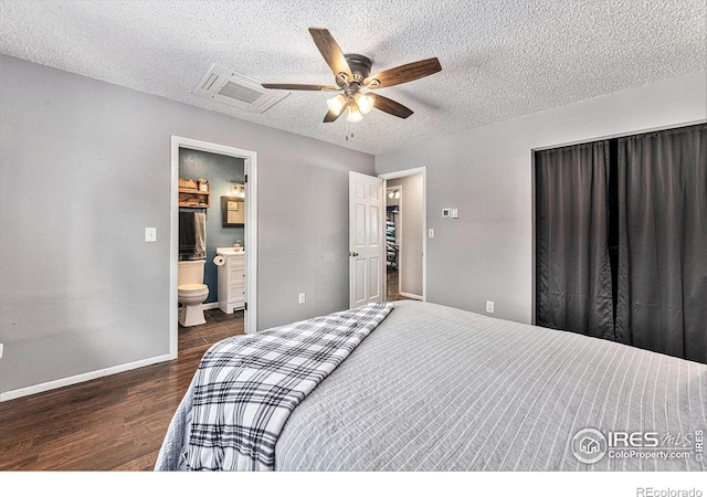 bedroom featuring ceiling fan, ensuite bathroom, dark wood-type flooring, and a textured ceiling