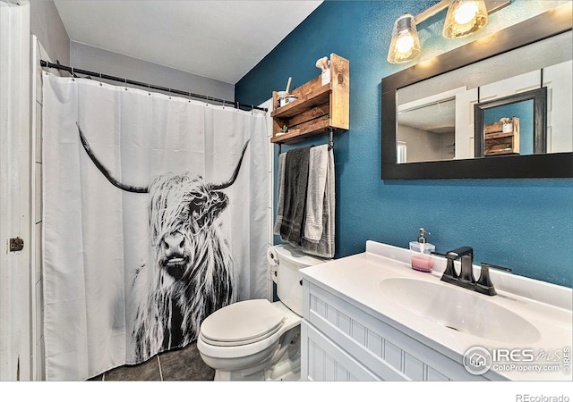 bathroom featuring tile patterned flooring, vanity, and toilet