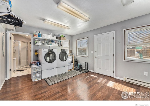 washroom with hardwood / wood-style flooring, a baseboard heating unit, and independent washer and dryer