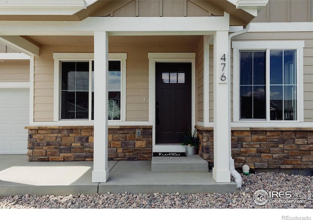 doorway to property with a porch and a garage