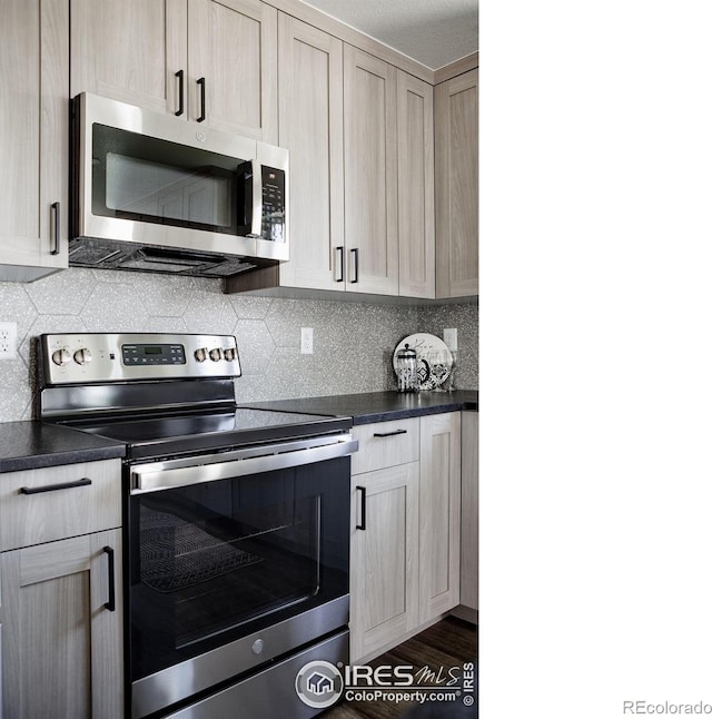 kitchen featuring tasteful backsplash, light brown cabinetry, stainless steel appliances, and dark hardwood / wood-style floors