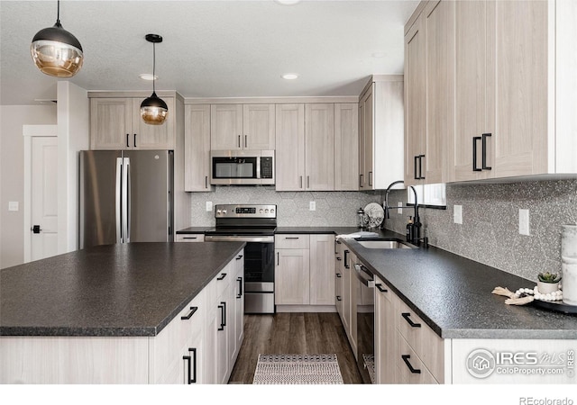 kitchen with dark wood-type flooring, sink, tasteful backsplash, pendant lighting, and stainless steel appliances