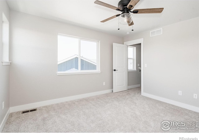 carpeted spare room with ceiling fan