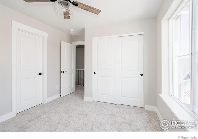 unfurnished bedroom with light carpet, a closet, and ceiling fan