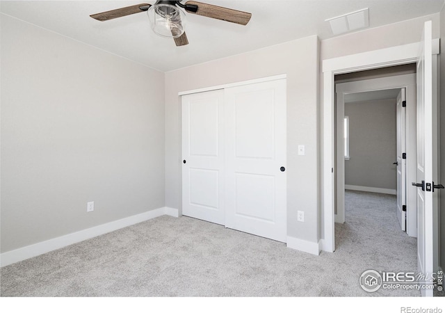 unfurnished bedroom featuring ceiling fan, light colored carpet, and a closet