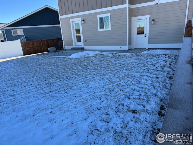 snow covered property featuring a patio