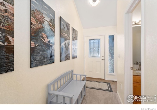 entrance foyer with carpet flooring and lofted ceiling