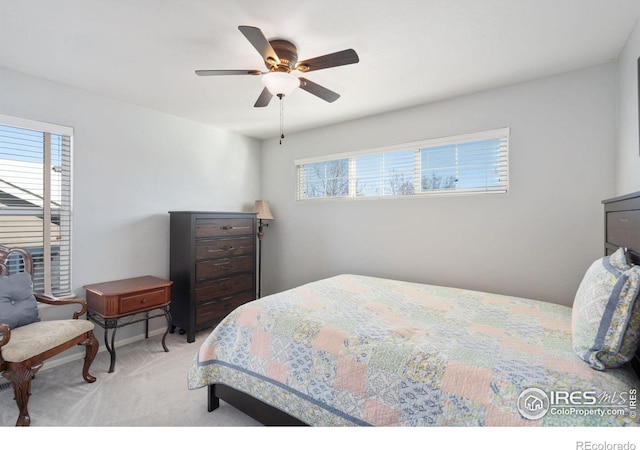 bedroom featuring multiple windows, light carpet, and ceiling fan