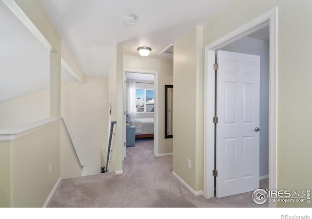 hallway with lofted ceiling with beams and light colored carpet