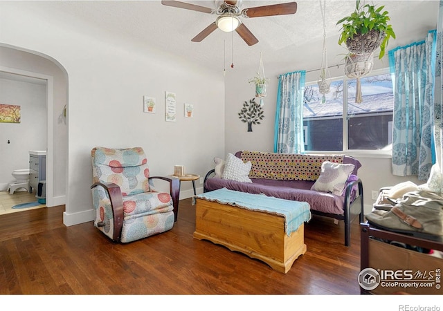 living room featuring ceiling fan, dark hardwood / wood-style flooring, and a textured ceiling