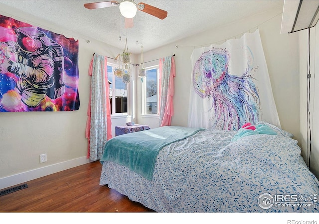 bedroom featuring a textured ceiling, ceiling fan, and dark wood-type flooring