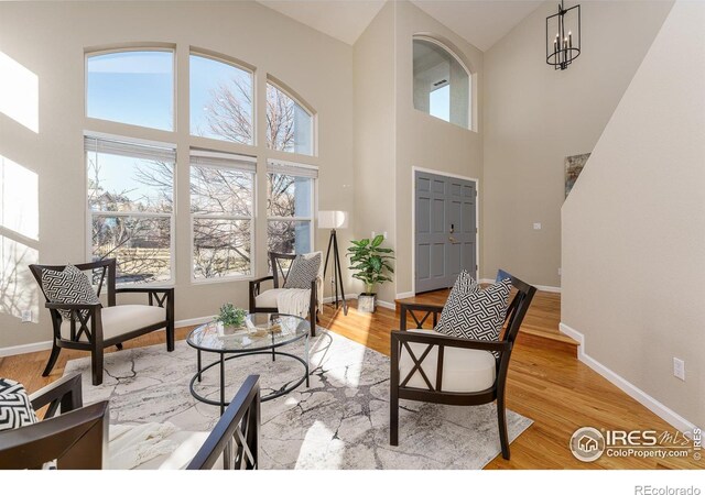 interior space featuring a high ceiling, an inviting chandelier, and light hardwood / wood-style flooring