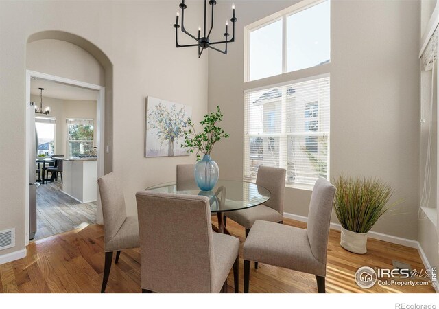 dining room featuring plenty of natural light, wood-type flooring, and a notable chandelier