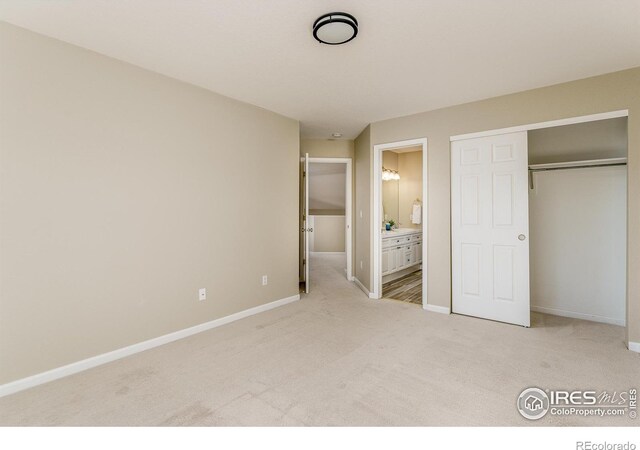 unfurnished bedroom featuring light carpet, connected bathroom, and a closet