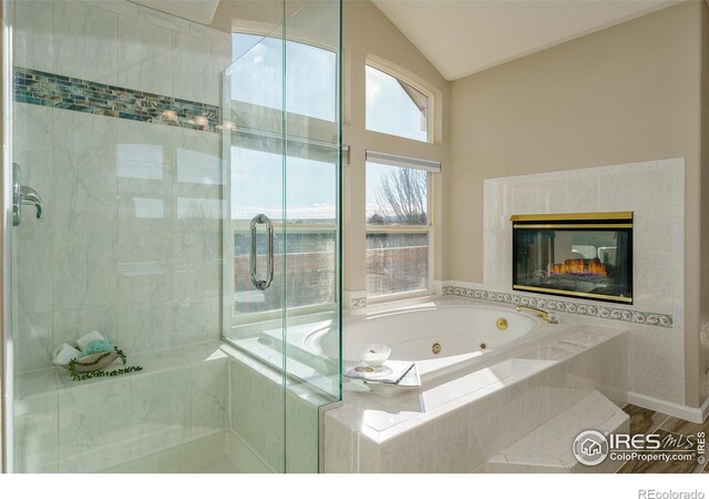 bathroom featuring hardwood / wood-style flooring, independent shower and bath, and vaulted ceiling