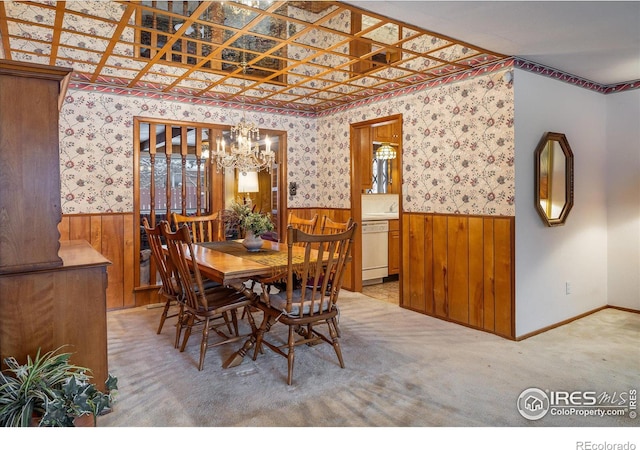 dining area with light colored carpet and a notable chandelier