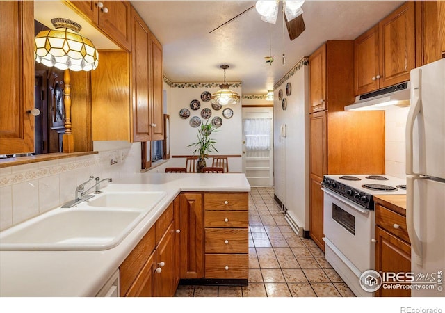 kitchen featuring kitchen peninsula, backsplash, white appliances, sink, and hanging light fixtures